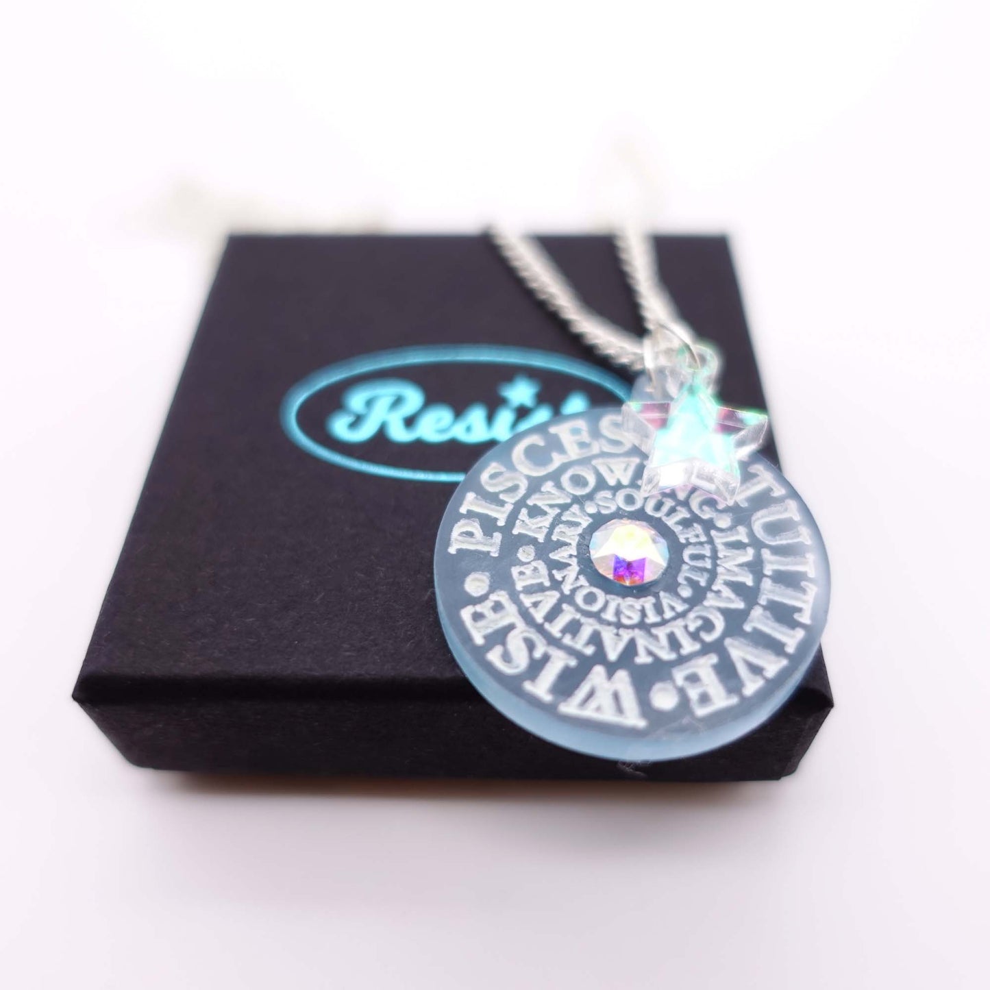 Close up of Pisces Zodiac Astrology necklace on box