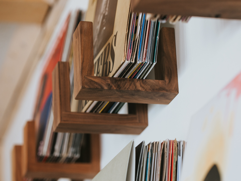 Flip Record Display Shelves in walnut holding and displaying records on the wall