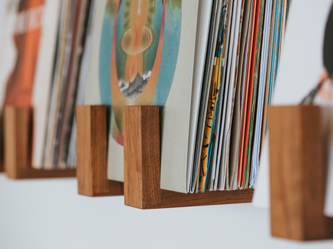 Flip Record Display Shelves in walnut displaying records on the wall. 