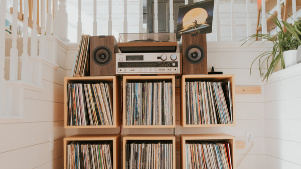 Vintage DUAL turntable and Sony receiver paired with modern KEF speakers on top of wall mounted cube shelves holding records