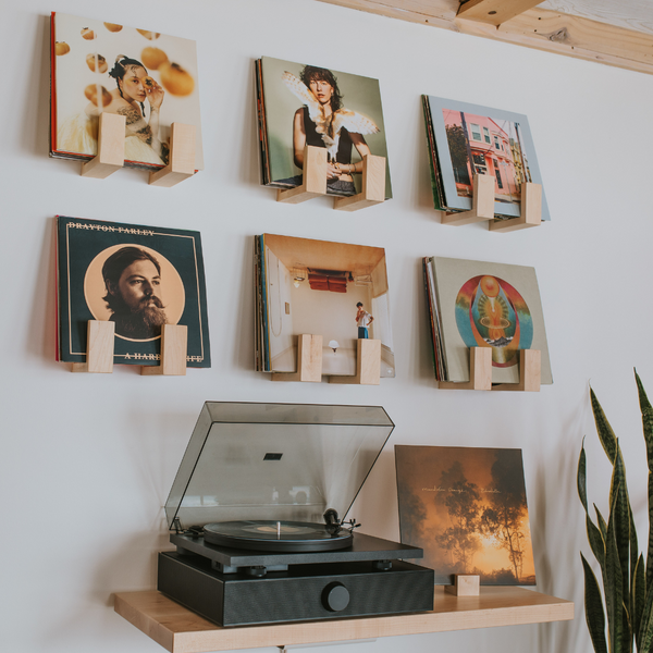 A set of 6 Flip Record Display Shelves showcasing the artwork of 6 records on the wall above a record player and a tabletop "now spinning" record stand
