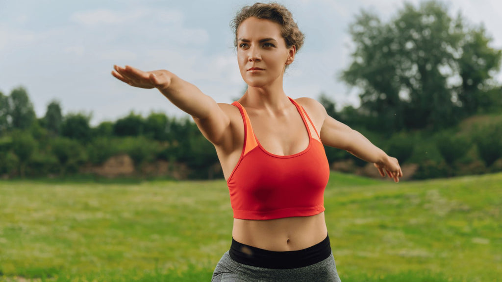 Woman in gym clothes exercising outside to boost her metabolism.