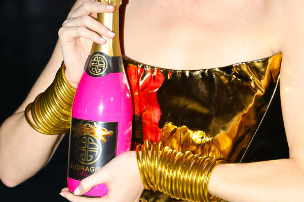 BuDhaGirl Sparkling Wines Bottle in Hands of a Model Wearing BuDhaGirl Bangle Bracelets at Ocean Drive Magazine's Art of the Party During Art Basel Miami Beach | BuDhaGirl