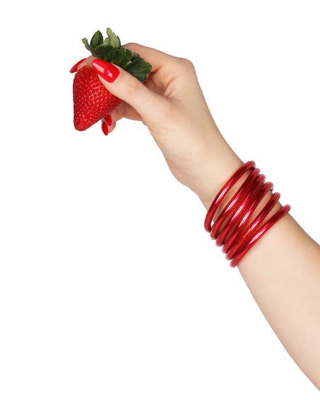 Model wearing BDG Pink All Weather Bangles while holding a strawberry | BuDhaBrief by BuDhaGirl