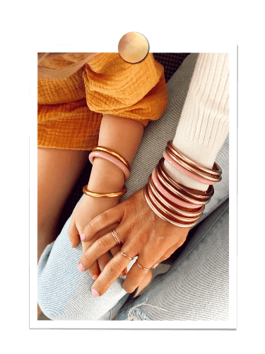 Baby girl Payton wearing BuDhaGirl bangles and holding her mother's hand Karli, also wearing BuDhaGirl Bangles.