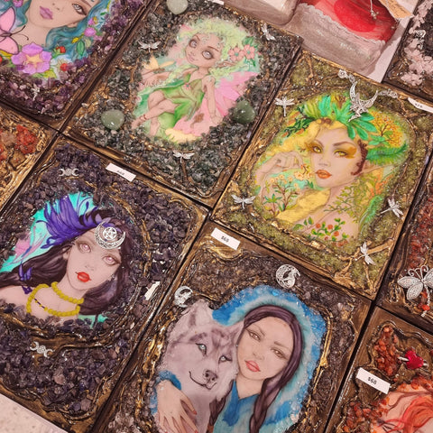 A collection of handmade and handpainted crystal journals and notebooks laying on a table