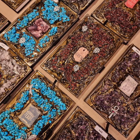 A collection of handmade crystal journals and notebooks laying flat on a table