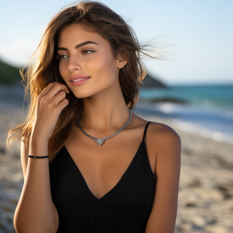 a woman wearing a diamond tennis bracelet and a diamond tennis necklace on the beach.