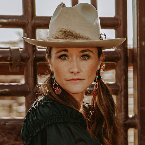 Model in a light colored cowgirl hat wearing aspen leaf earrings by Buckaroo Bling