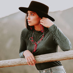 Model in a cowboy hat wearing red jewelry by Buckaroo Bling