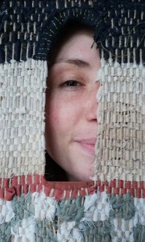 Shot of Emily Unsworth White looking through her woven shrine window