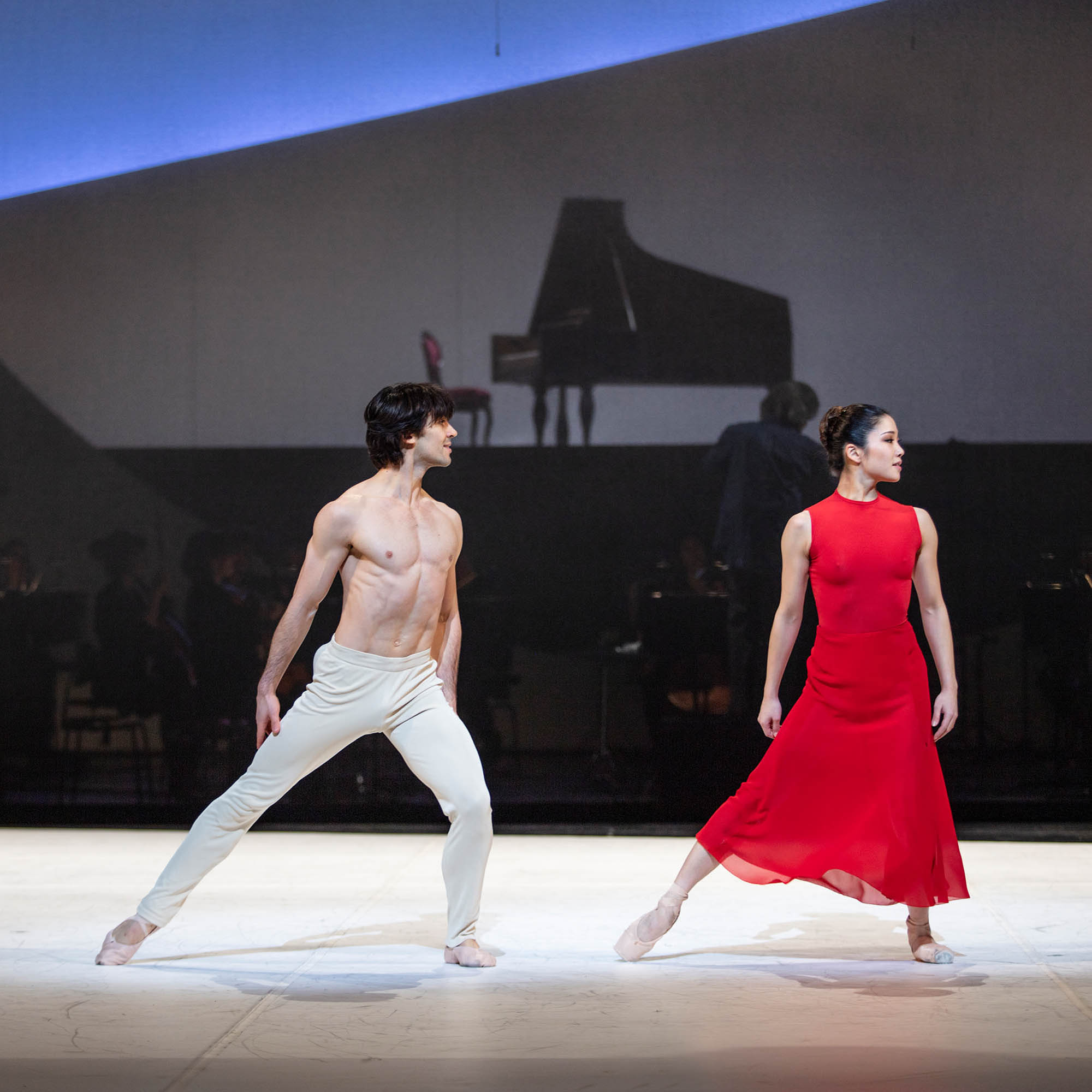 Ballettänzer der Hamburger Staatsoper, wovon die Ballerina ein rotes, langes Kleid von Akris trägt