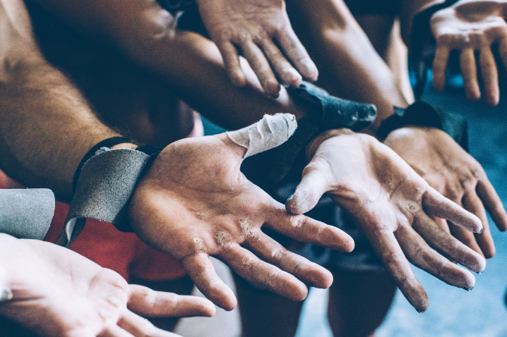 A group of athletes rough hands showing their calluses with wrist support wraps