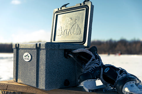 Glacière Chilly Moose de 25 L de couleur Moonstone présentée sur un banc en bois avec des patins de hockey noirs appuyés sur la glacière.