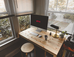 Desktop computer showing an online streaming service, on a desk facing a window.