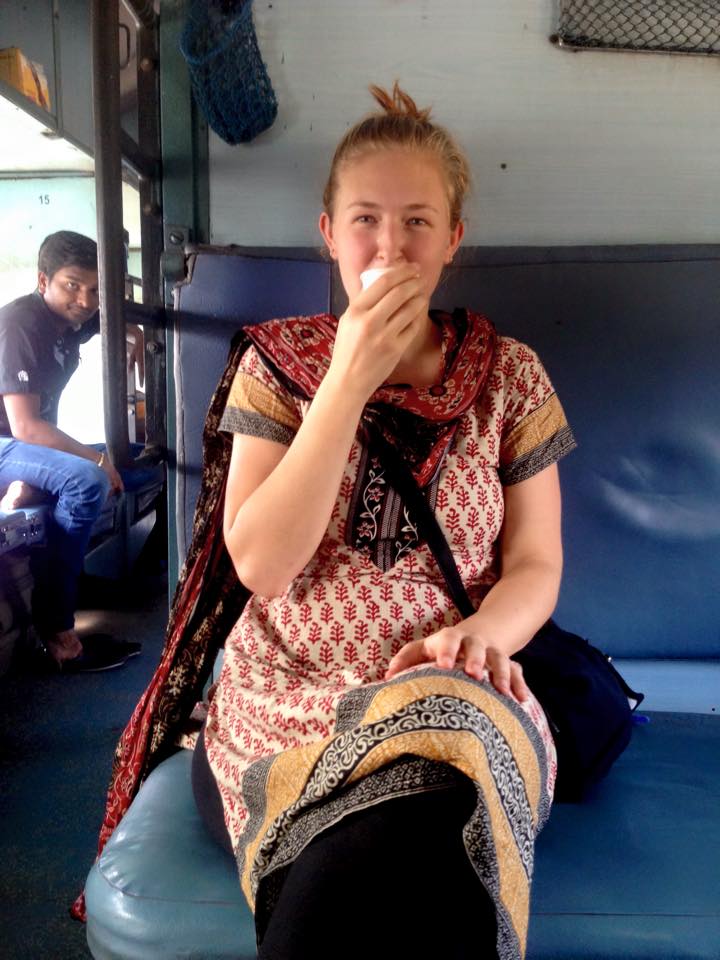 Woman smiling and drinking tea on a train