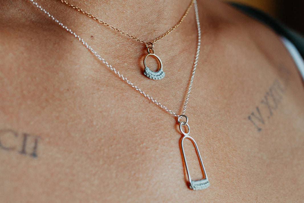 Close up image of someone's neck focusing on two layered necklaces