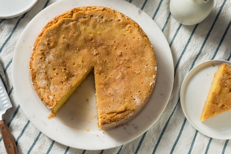 Olive Oil Cake on a plate with a slice mising