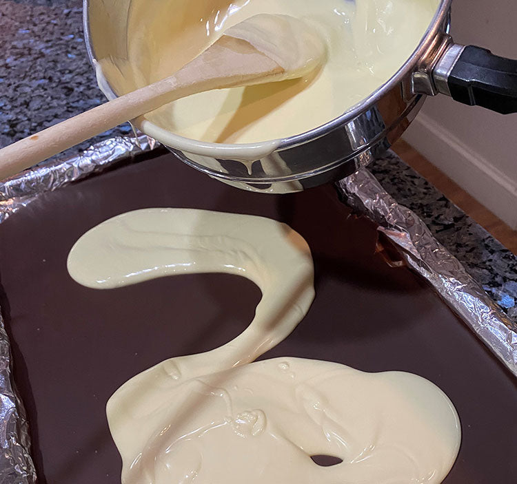 Pour the white chocolate over the dark chocolate