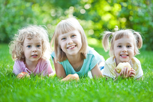 Magnesium for kids: 3 kids lying on the grass