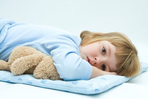 Can kids take melatonin: baby laying down and hugging a stuffed toy