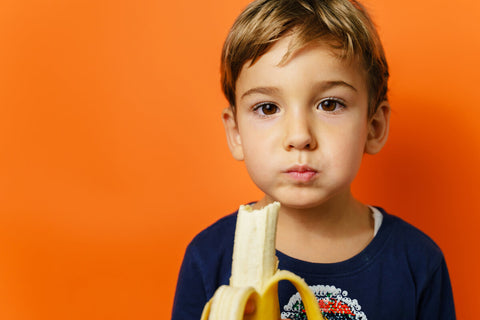 Little boy eating a banana
