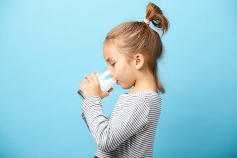 Iodine for kids: little girl drinking a glass of milk