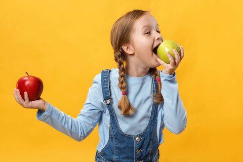 Gut health for kids: little girl eating an apple