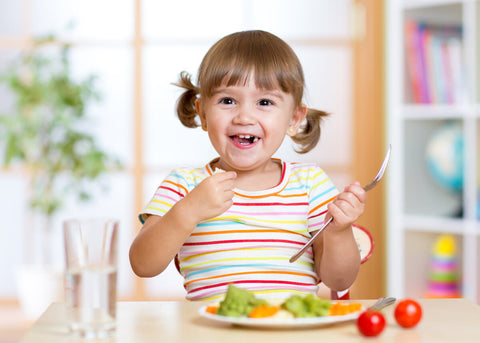Best vitamins for kids: girl eating vegetables