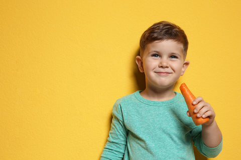 Little boy holding a carrot