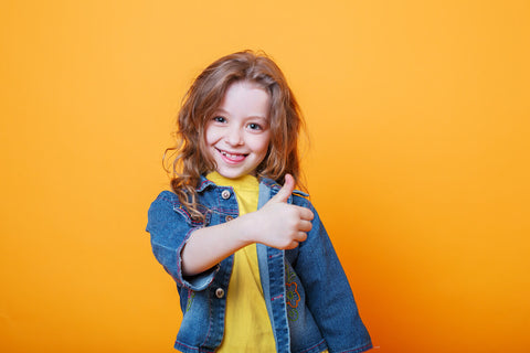 Niacin for kids: happy, little girl giving a thumbs-up