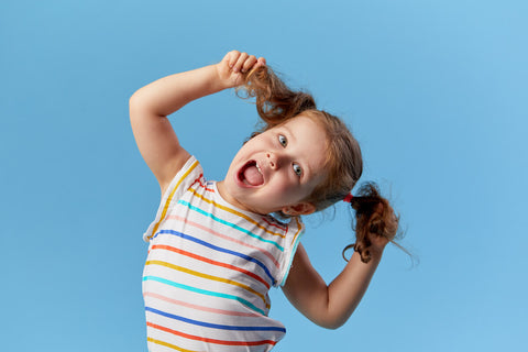 Niacin for kids: happy, little girl holding her pigtails