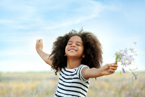 Happy girl enjoying the outdoors and holding some flowers