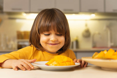 Happy kid about to eat a mango