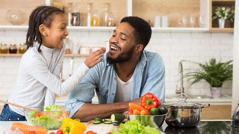 Nutrients for kids: kid giving his father vegetables