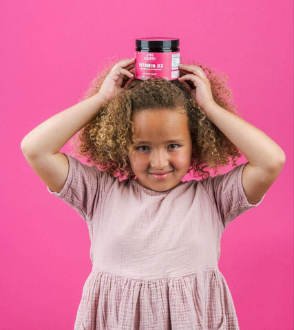 Little girl holding a jar of Llama Naturals on her head