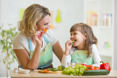 Mom and daughter eating vegetables