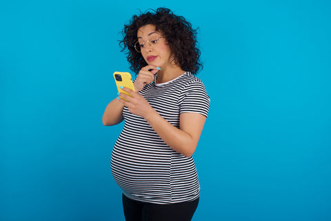 Vitamin C while pregnant: pregnant woman using a phone