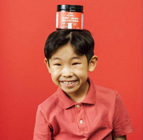 Electrolytes for kids: smiling boy with a Llama multivitamin jar on his head