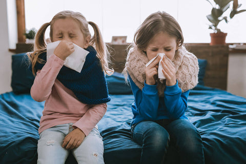Zinc for kids: 2 sick girls blowing their nose