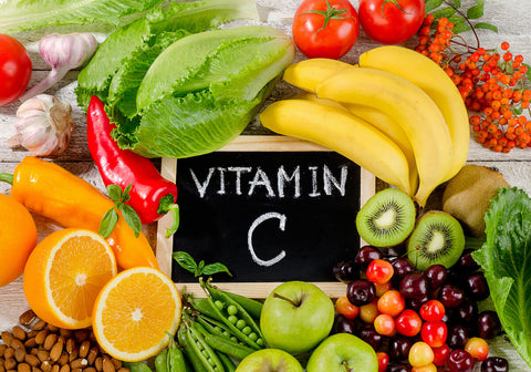 Vitamins for metabolism: Vitamin C written on a chalkboard surrounded by fruits and veggies