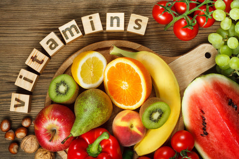 Vitamins for metabolism: vitamins spelled using letter blocks beside various fruits