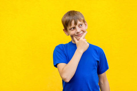 Young boy thinking about when the best time of day to take vitamins is