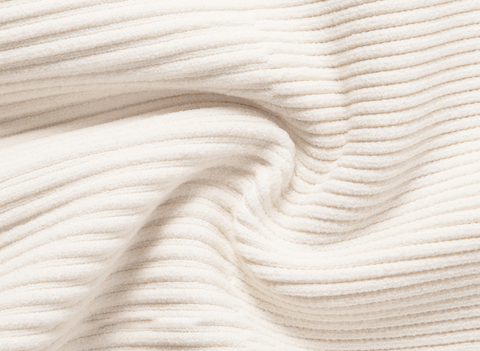 Close-up texture of a cream-colored ribbed fabric