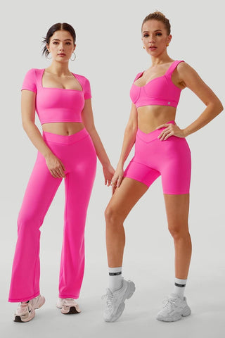 Fashion image featuring two models in matching hot pink sportswear