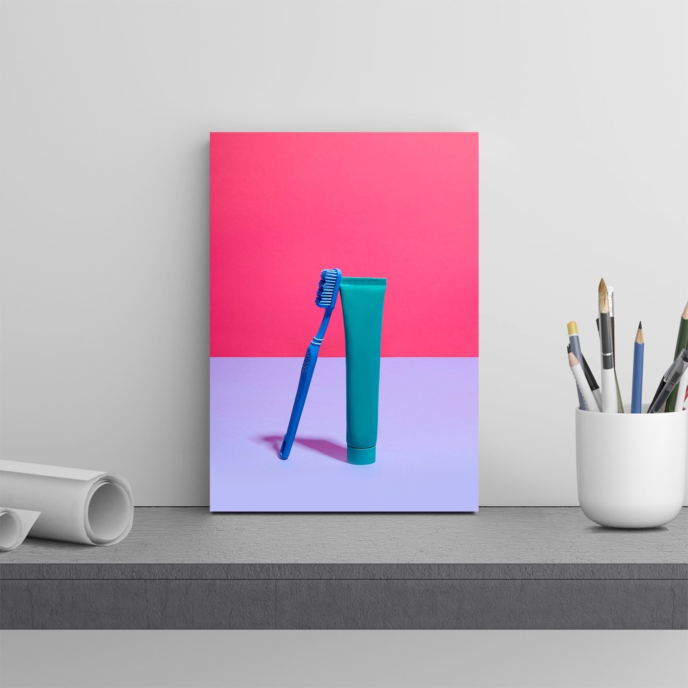 Toothbrush and toothpaste against pink and lilac background