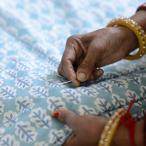 Seamstress hand stitching the hem off Molly Mahon's new quilt designs