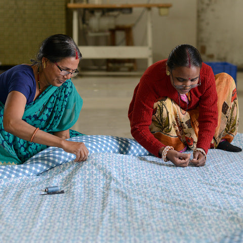 Seamstresses hand stitching a Molly Mahon quilt