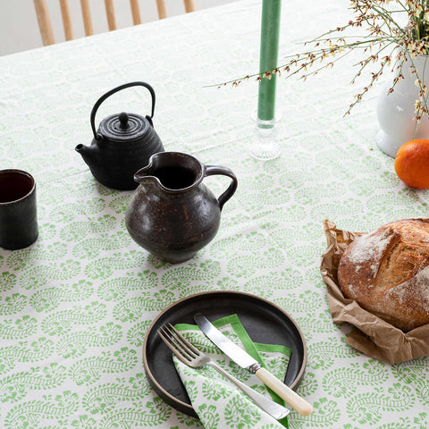 Close up of Lani Green Table Cloth with a tea set laid upon it in a lovely kitchen setting