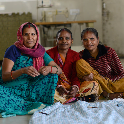 Three Seamstress Ladies very proudly sitting with their hard work on Molly Mahon's new quilt designs